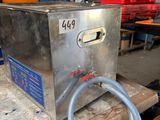 une boîte métallique à laquelle est raccordé un tuyau, posée sur une table