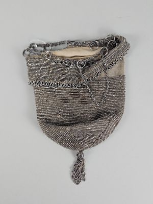 un vieux sac à main accroché au mur, entouré d'une chaîne