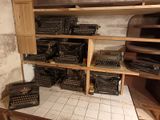 many type of typewriters on the shelves in this room