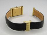 an image of a black and gold wrist watch with a gold buckle