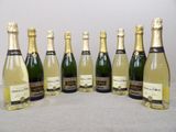 six bottles of champagne lined up in a row on a table