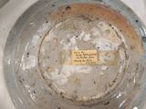 a glass bowl with a label on it sitting on a table