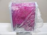 a pink tissue sitting in a plastic box on a sink