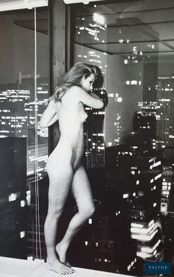 black and white photograph of a naked woman standing on a ledge in front of a window