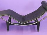 an image of a black chaise lounger on a purple background