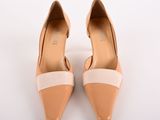 beige and white high heeled shoes on a white surface