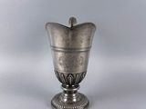 a silver vase that is sitting on a table