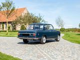a blue car that is parked on a cobblestone road