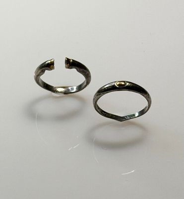 pair of silver rings on a white surface