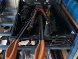 two pairs of scissors hanging from a rack in a garage