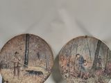 deux assiettes sur lesquelles figurent un homme et une femme dans un cadre boisé