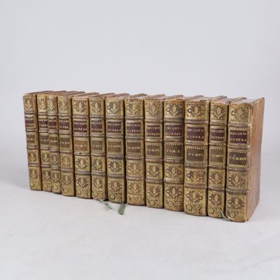 six vieux livres sont empilés sur une surface blanche