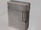 an old silver cigarette case sitting on top of a glass table