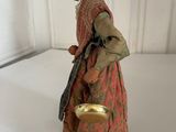 figurine of an old woman with a bowl and a cane