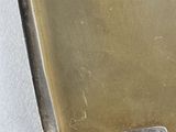 a metal tray with a metal handle on a white surface