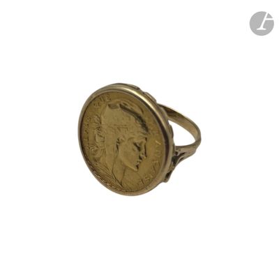 un gros plan d'une bague sur laquelle est posée une pièce de monnaie
