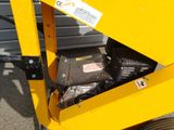 a close up of a small yellow machine on the ground