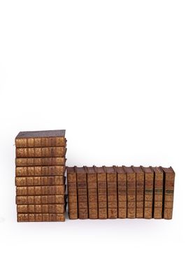 several old books stacked on top of each other on a white surface