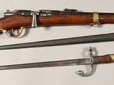 trois types d'armes différents sont exposés sur une surface blanche