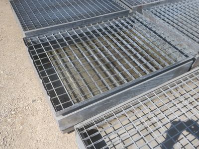 une grille métallique posée au sol à côté d'une autre grille métallique