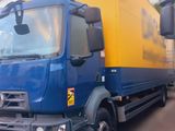 un camion bleu et jaune garé devant un immeuble