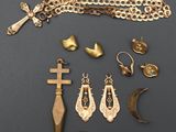 un assortiment de bijoux en or, comprenant notamment une croix, un poignard et d'autres objets