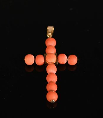 an image of a cross made out of coral beads on a black surface