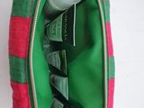 a pink and green bag with a bottle of lotion inside of it