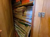 a closet full of books and papers in the corner of the room