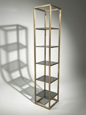 a close up of a book shelf with a shadow on the wall
