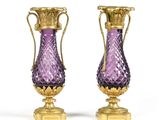 paire de vases en verre violet avec des anses dorées sur fond blanc