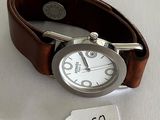 a wrist watch with a leather band and a price tag