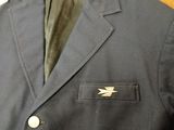 a close up of a jacket on a wooden table with a tag on it