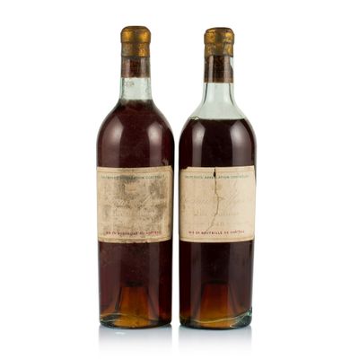 two bottles of wine sitting next to each other on a white surface