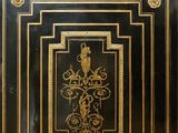 a black and gold cabinet with a clock on top of it
