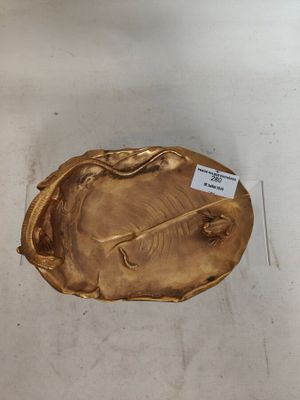 une plaque en or posée par terre, sur laquelle est accrochée une étiquette
