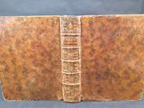 un vieux livre à la couverture brune posé sur une table