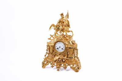 a gold clock that is sitting on a white surface