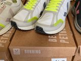 several pairs of running shoes sitting on top of boxes on a table