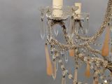 a chandelier that has a candle and some beads hanging from it