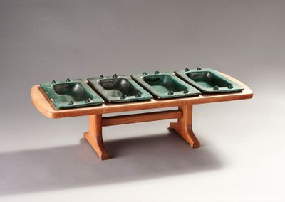 a wooden table with four green bowls on it