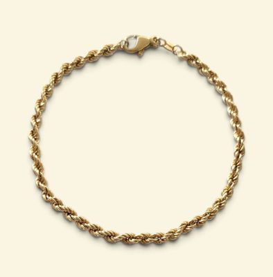 un gros plan d'un bracelet en chaîne dorée sur fond blanc