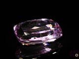 purple diamond on a black surface with reflection
