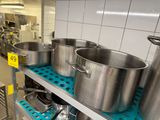 several pots and pans are on a shelf in a kitchen