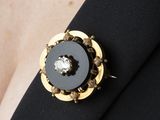 un gros plan sur une broche noire et dorée