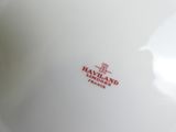 a close up of a white bowl with a red logo on it