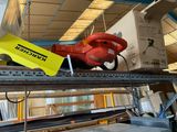 a red fire hydrant sitting on top of a shelf in a warehouse