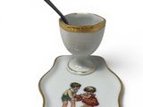 a small cup and saucer with a spoon on it