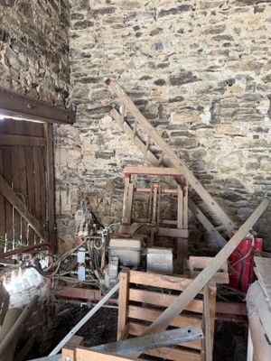 a room with a stone wall and a wooden chair