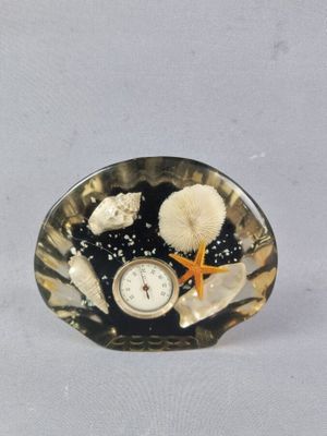 une horloge posée sur un coquillage